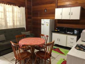 eine Küche mit Tisch und Stühlen und einem Kühlschrank in der Unterkunft Residencial Alvorada in Bombinhas + 12 Fotos