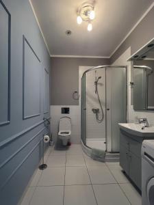 a bathroom with a shower and a toilet and a sink at Apartament Na Chłodnej | The High Street in Suwałki