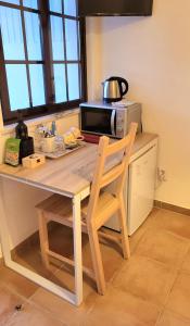 cocina con mesa, silla y microondas en Cantinho de Milfontes Jacuzzi en Vila Nova de Milfontes