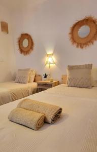 2 camas en un dormitorio con 2 espejos en la pared en Cantinho de Milfontes Jacuzzi, en Vila Nova de Milfontes