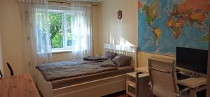 une chambre avec un lit, une fenêtre et une carte du monde dans l'établissement Cozy Telliskivi apartment near city centre, à Tallinn