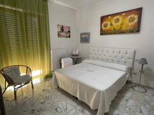 マッティナータにあるOrchidea Mattinata parco del Garganoのベッドルーム(白いベッド1台、椅子付)
