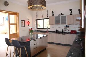 a kitchen with a counter and some chairs in it at Dar Lalla Mhalla Villa 975m2 5ch - Rt de Fes in Marrakesh