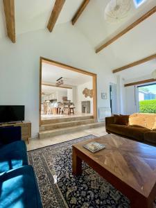 ein Wohnzimmer mit einem Sofa und einem großen Spiegel in der Unterkunft Maison en Normandie - 5 min plage Houlgate - Villers sur mer in Auberville