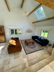 ein Wohnzimmer mit einem Sofa und einem Tisch in der Unterkunft Maison en Normandie - 5 min plage Houlgate - Villers sur mer in Auberville