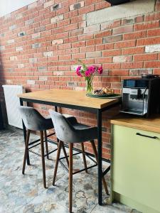 a wooden table with two chairs next to a brick wall at Loveloft226 in Żyrardów +13 photos