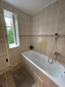 a white bath tub in a bathroom with a window at Apartmán AkoDoma in Tatranská Lomnica