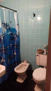 a bathroom with a toilet and a shower curtain at Billinghurst buenos aires in Buenos Aires