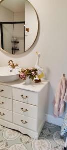 baño con lavabo y tocador con espejo en Butterfly Guesthouse - Entire Home within 5km of Galway City, en Galway