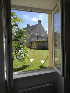 an open window with a view of a house at Jadis, l'école de Maisy, port et plage au bout de l'avenue in Grandcamp-Maisy