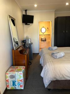 a hotel room with two beds and a mirror at The Water Wheel in Vryheid