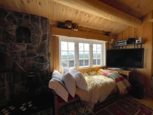 Zimmer mit einem Bett, einem TV und einem Fenster in der Unterkunft Snikkerplassen - cabin with amazing view and hiking opportunities in Sør-Fron