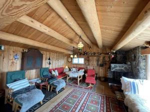 ein Wohnzimmer mit Holzdecken und -möbeln in einer Hütte in der Unterkunft Snikkerplassen - cabin with amazing view and hiking opportunities in Sør-Fron