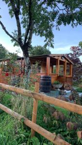 uma cerca de madeira com uma casa ao fundo em Songbird Lodge - Near brew pub/10 mins from Snowdon em Caernarfon