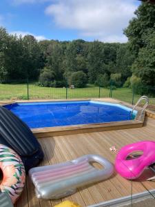 una piscina con una silla y un flotador rosa en Maison de campagne de plein pied., en Plougonven