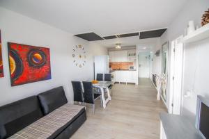 Pandora apartment في لاس غاليتاس: غرفة معيشة مع أريكة وغرفة طعام