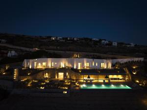 a large building with a swimming pool at night at Olithos Villas in Krotiri