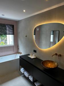 a bathroom with a sink and a large mirror at Bed en Baguette in Burgh Haamstede