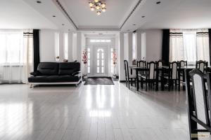 uma sala de estar com um sofá preto e cadeiras em Sweet Home Bucovina Frasin petreceri private si majorate em Frasin