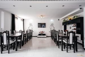 uma sala de jantar com mesas e cadeiras pretas em Sweet Home Bucovina Frasin petreceri private si majorate em Frasin