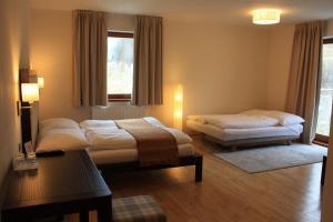 ein Schlafzimmer mit zwei Betten und einem Tisch und einem Fenster in der Unterkunft Villa Malina in Oščadnica