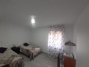 1 dormitorio con 2 camas y ventana. en CASA BARAKALDO, en Barakaldo