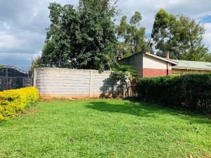 een hek in een tuin naast een huis bij Plush 3 Bedroom Apartment Home in Kitale