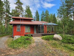 una casa roja en medio de un bosque en Loma-asunto Ahven, Kalajärvi, Maatilamatkailu Ilomäen mökit, en Seinäjoki