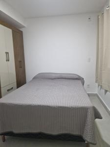 a bed in a white room with a large mattress at Souza Lofts Centro Praça Tiradentes in Teófilo Otoni