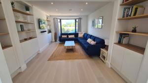 ニューキーにあるLuxury home near Fistral Beachの青いソファとテーブルのあるリビングルーム