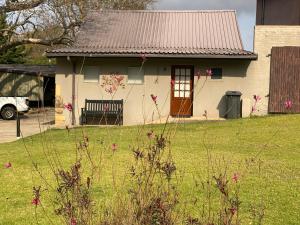 a small house with pink flowers in front of it at The Water Wheel in Vryheid