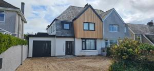 ニューキーにあるLuxury home near Fistral Beachのガレージ付きの大きな木造家屋