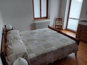 1 dormitorio con 1 cama, 1 silla y ventanas en Alloggio Petrigh 2, en Canal di Grivo