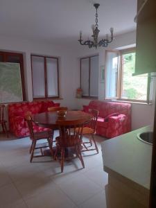 sala de estar con mesa, sillas y sofá en Alloggio Petrigh 2, en Canal di Grivo