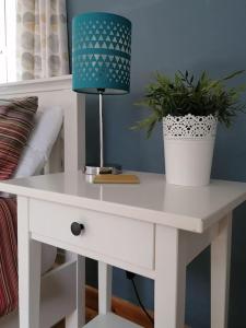 a white desk with a lamp and plants on it at The Little House, Wadebridge, Cornwall in Wadebridge +24 photos