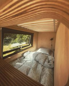 a small bedroom with a bed and a window at Elevated Tiny House Glamping in Tjøme