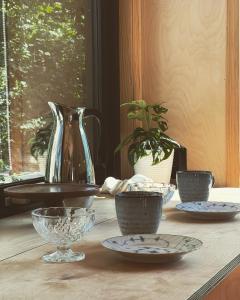 a table with bowls and plates on it with a vase at Elevated Tiny House Glamping in Tjøme +12 photos