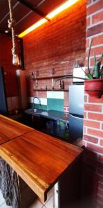 a kitchen with a counter with a sink and a brick wall at Joske in Arequipa