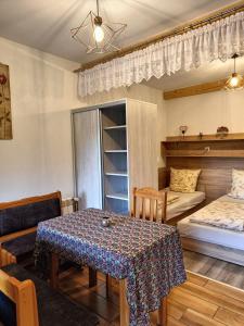 a room with a table and a bed and a bedroom at Pod Modrzewiami in Milówka