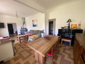 een woonkamer met een houten tafel en een piano bij CHEZ SYLVIE BY CHRISTOPHE in Les Salles-du-Gardon