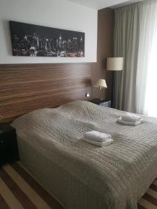 a bedroom with a bed with two towels on it at Apartament prywatny salon z aneksem kuchennym i sypialnią w hotelu Diva in Kołobrzeg