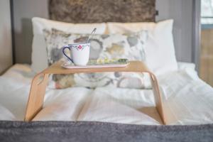 a coffee table with a cup on a bed at Naturum Vänerskärgården - Victoriahuset in Lidköping