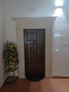 a wooden door in a room with a vase of flowers at Tiny House Alferi in LʼAquila