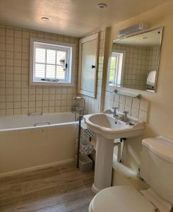 a bathroom with a tub and a sink and a toilet at Gorgeous Cottage in Skirmett with Parking in Henley on Thames