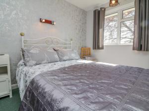 a bedroom with a bed and a window at Stagsholt Lodge in Washfield
