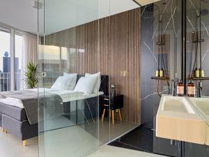 a bedroom with a bed and a sink and a tub at Exclusive Penthouse with Sunset Views in Copenhagen