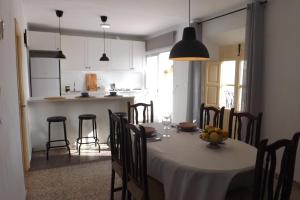 a dining room with a table and chairs and a kitchen at Casa Elvira in Cómpeta