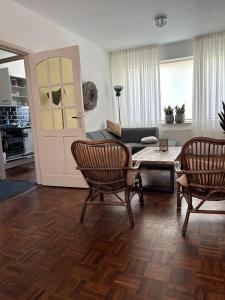salon z kanapą, stołem i krzesłami w obiekcie Maisonette De Proper Katwijk w mieście Katwijk