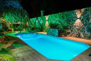 una piscina en un patio trasero por la noche en Kasakolà, en Palomino