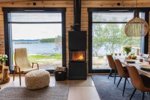 a living room with a fireplace and a table and chairs at Upea Villa Lapin Kulta hirsihuvila Inarijärven rannalla in Inari